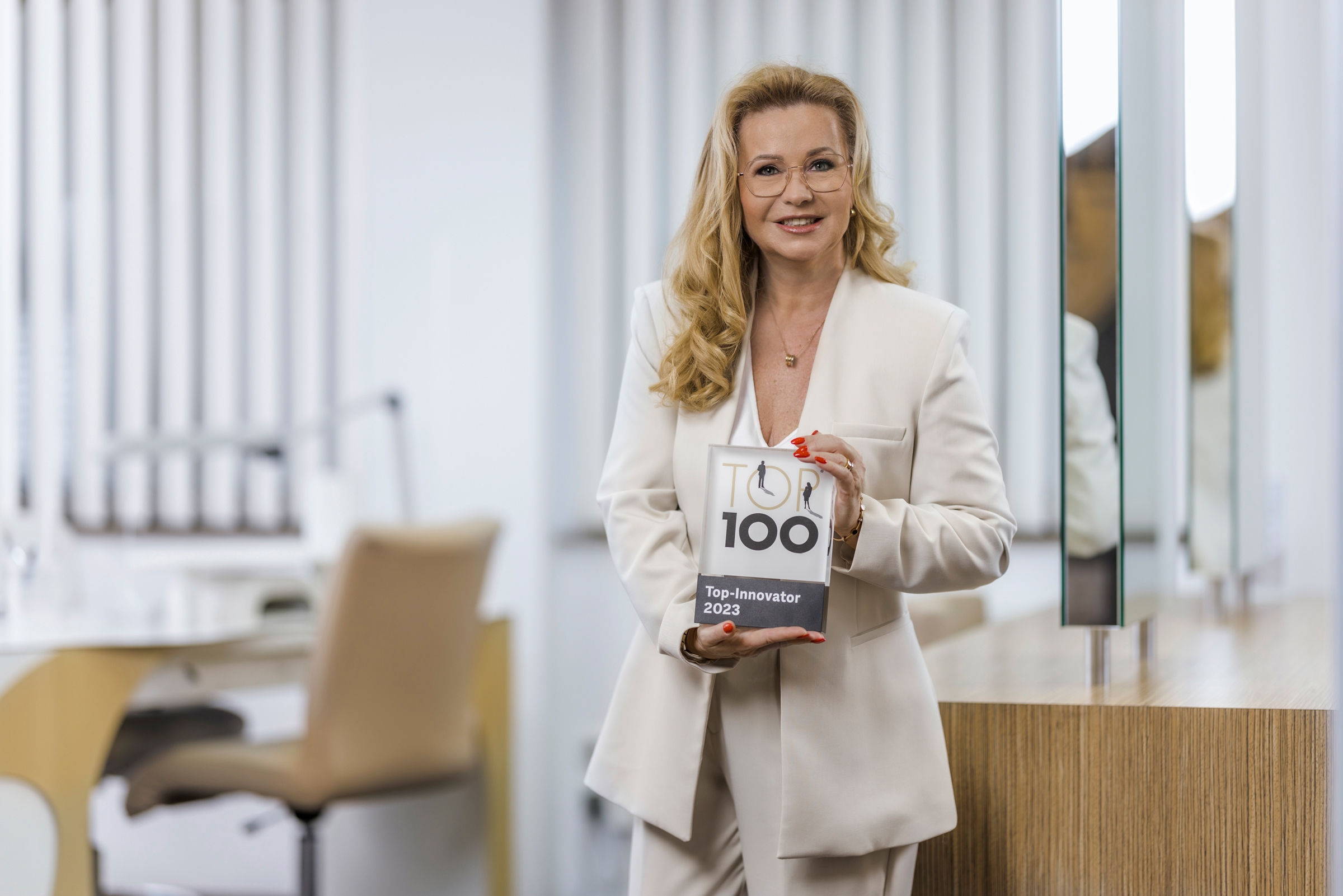 Nicole Simon hält den Auszeichnung in der Hand als Top-Innovator 2023.